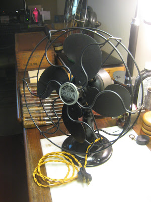 Restored Emerson antique fan with renewed black finish, clean guard, blades and cloth-covered cord.