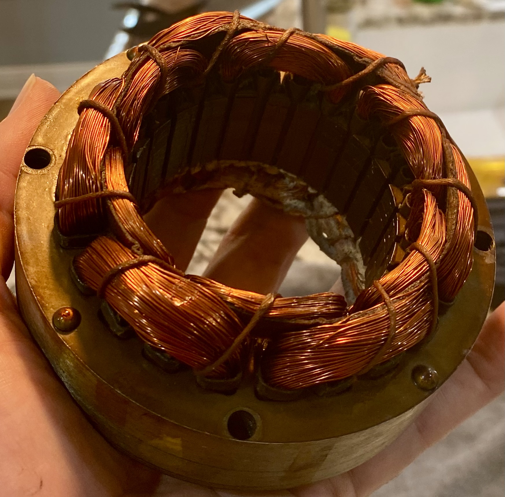 Vintage winding bench with copper coils, stator assembly and Edison lamps.